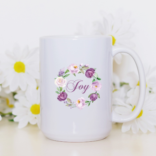 Mug that says "Joy" surrounded by a wreath of pink and purple flowers.
